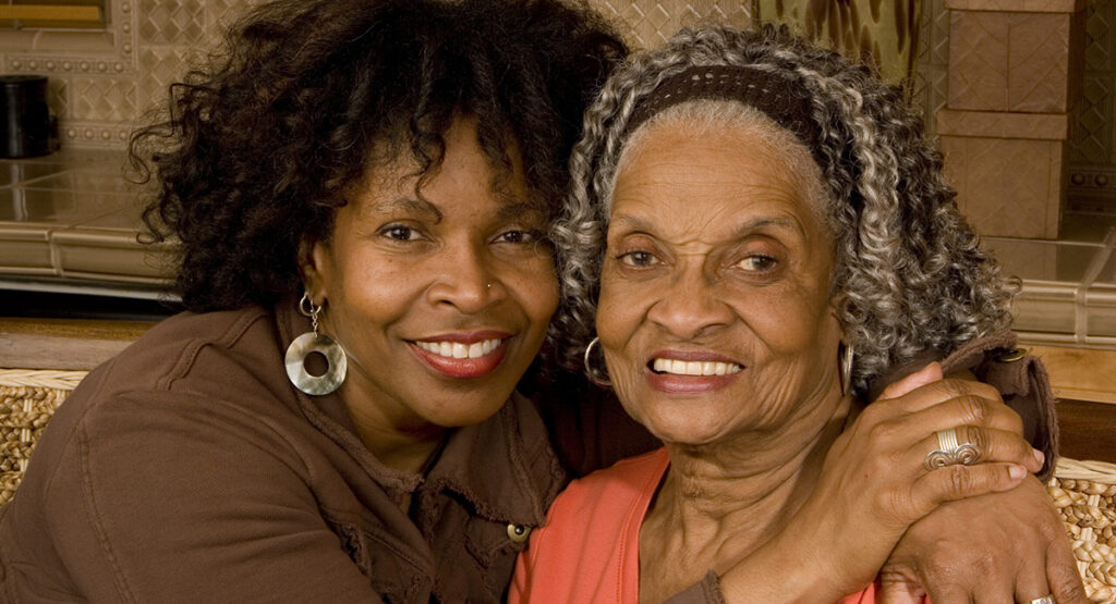 Portrait of a senior African American woman hugging her daughter.